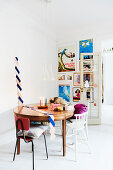 Antique table with chairs and a gallery wall behind a door