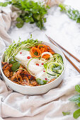 Chicken Noodle Bowl mit Zucchini, geraspelter Karotte und frischen Kräutern