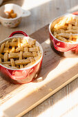 Apple biscuits with dough lattice in small baking dishes