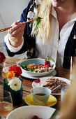 Woman eats poke bowl with buckwheat noodles and tuna