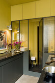 Grey furniture in a kitchen with yellow walls