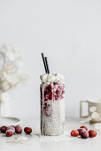 Cocktail with almond milk, chia seeds, cherries and coconut whipped cream