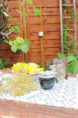 Jam jar with DIY lid made of birch bark and flowers on table