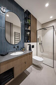 Elegantes Badezimmer mit Waschtisch und Duschkabine aus Glas