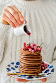 Chocolate pancakes with red currants, a woman is holding a saucer