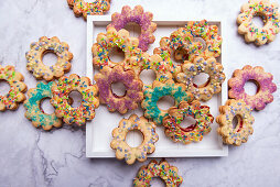 Vegan shortcrust biscuits with a jam filling and colourful sugar decorations