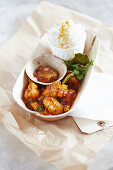 Kozhy curry (spicy chicken in coconut milk, India) in a take-away box