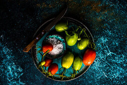 Ingredients for raw salad with fresh organic cherry tomatoes, sea salt and olive oil on cutting board