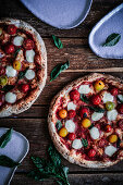 Hausgemachte Pizza mit Cherrytomaten und Mini-Mozzarella