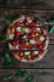 Home made pizza with cherrytomatoes and mini-mozzarella
