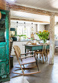 Rocking chair in a robust kitchen with concrete floor and wooden beams