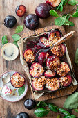 Baked plums with granola and almond flakes