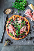 Pizza with ham and blackberries