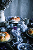 Easter table with coloured eggs and yeast wreath