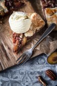 Slice of a plum galette with a scoop of vanilla ice-cream