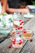 Several glasses of splashes of rosé wine and vodka on a table in the garden