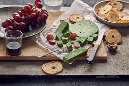 Green pesto gouda with red grapes and bread chips