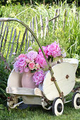 Pink peonies, lady's mantle and Galium in a nostalgic doll's pram