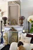 Hydrangeas in urns and picture frame on mantelpiece