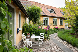 Small seating area in front of yellow-painted house