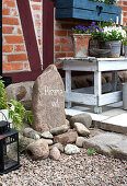 Stone decoration and wooden bench with flower pots on the terrace