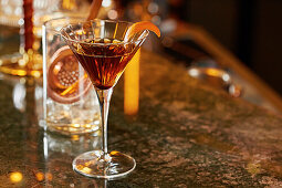 Whiskey-Cocktail im Martiniglas, garniert mit Orange