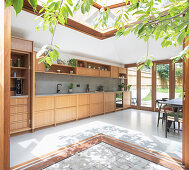 Blick vom Innenhof auf maßgefertigte Küche mit Holzfronten