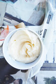 Mayonnaise in a small bowl on newspaper