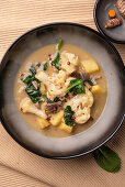 Vegan cauliflower curry with potatoes, mushrooms and spinach