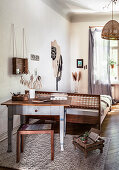 Table with drawers, stool and double bed in studio apartment