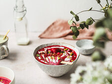 Smoothie with fresh berries and ice candy with crushed pistachios and yogurt in bowl