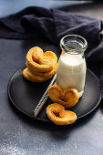 Traditional Puff pastry spiral biscuits known as a pig's ears on plate with sugar