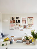 A table with flowers and rustic stoneware with a view of a picture gallery