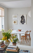 A stack of books and a bouquet of flowers with a view into the dining room of an old building