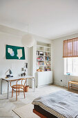 A coffee house chair at a desk in a bedroom with a bookshelf