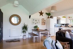 View of dining area with table and benches in open living room