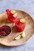 Zwei Gläser Berry-Vodka-Tonic mit Johannisbeeren und Limette