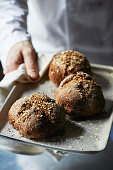 Freshly baked crusty rolls on a baking tray