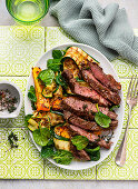 Roast beef steak with pepper and thyme on a grilled Zucchini salad