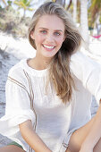 Young blonde woman in white blouse outdoors