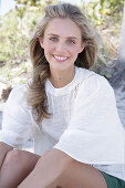 Young blonde woman in white blouse outdoors