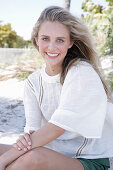 Young blonde woman in white blouse outdoors