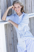 Young, blond woman in light blue shirt and striped trousers