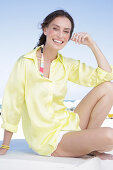 Brünette Frau in gelber Bluse und weißen Shorts am Strand