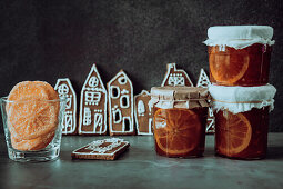 Jars of homemade orange marmalade, decorated gingerbread and candied orange slices