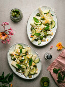 Melon salad with cucumbers and olives served on plate with herbs near salt shaker and napkin