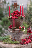 Tower of terracotta pots with ornamental apples and candles as Advent wreath
