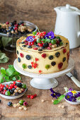 Biskuit-Buttercreme-Torte mit Beeren und Champagnergelee überzogen