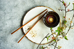 Spring table setting with chopsticks decorated with blooming cherry tree branches