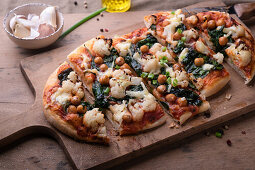 Vegan spelt pizza with cauliflower, chickpeas, and spinach
